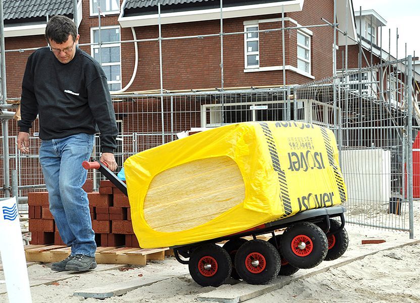 Budowlaniec przywozi materiały budowlane na wózku transportowym Matador